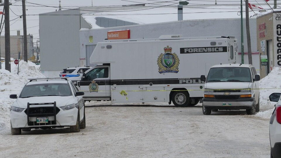 La photo montre plusieurs véhicules de police dont un camion de la police judiciaire. 