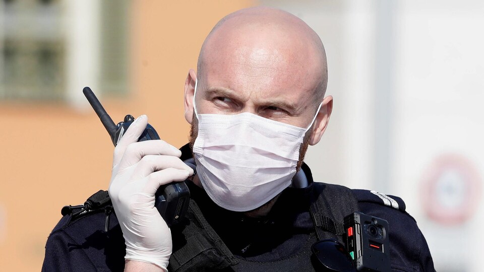 Un policier portant un masque et des gants.