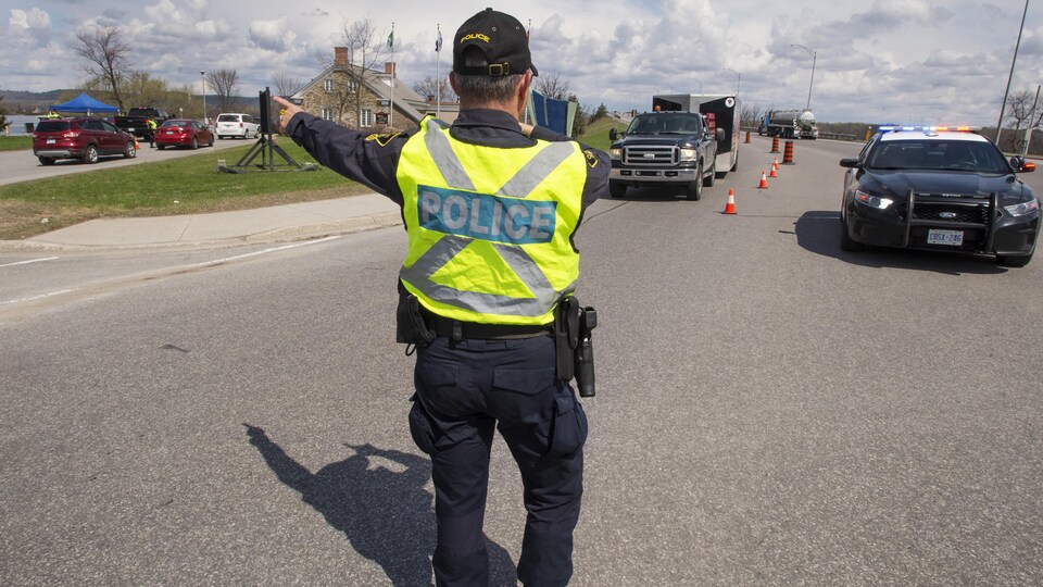 Un agent de la Police provinciale de l'Ontario contrôle le passage des automobilistes à la frontière, à Hawkesbury.