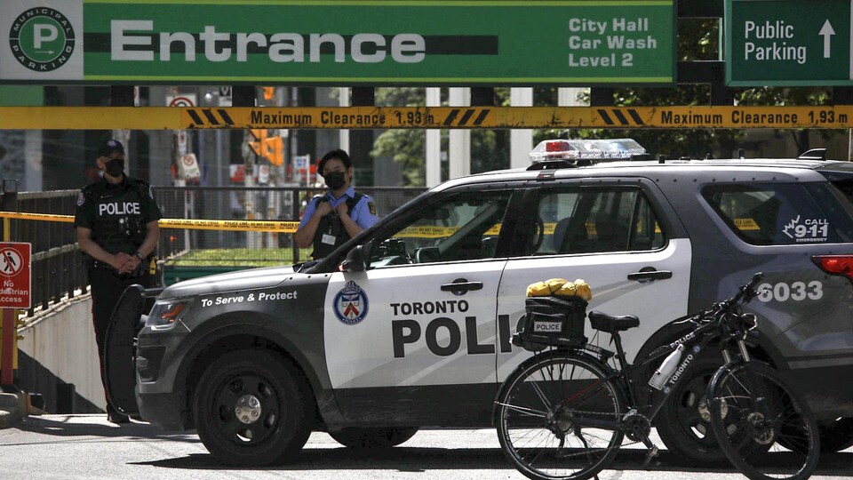 Des policiers montent la garde à l'entrée du stationnement de l'hôtel de ville de Toronto après le meurtre de l'agent Jeffrey Northrup.