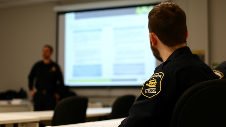 Un policier du Service de police de la Ville de Québec est assis dans une salle de formation.