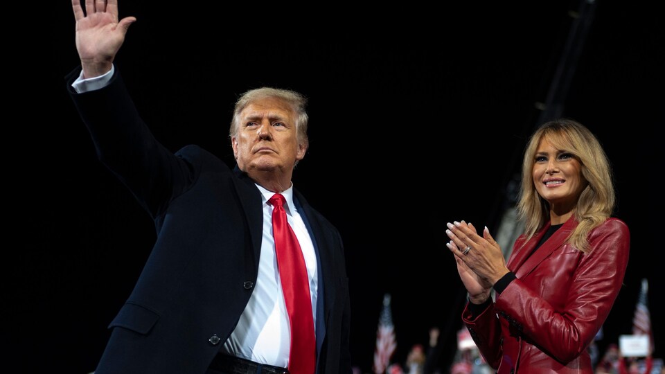 Eski Başkan Donald Trump, eşi Melania Trump ile destekçilerine el sallıyor.