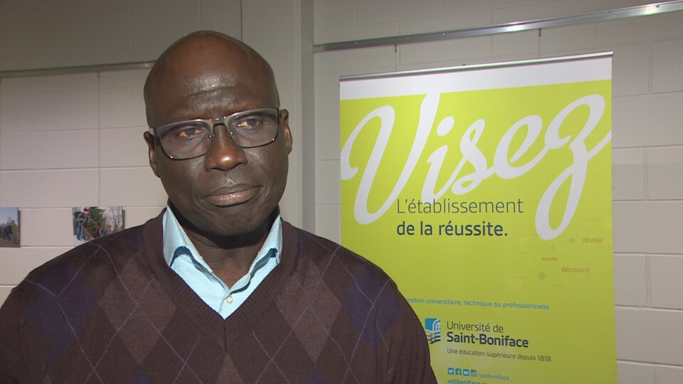 Mamadou Ka debout dans un corridor.