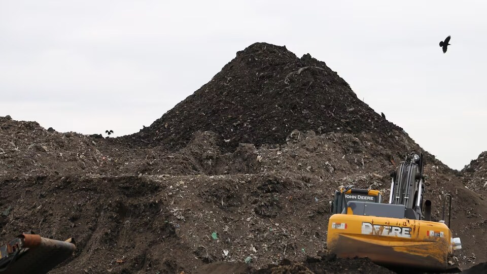 Une montagne de compost entourée de deux engins.