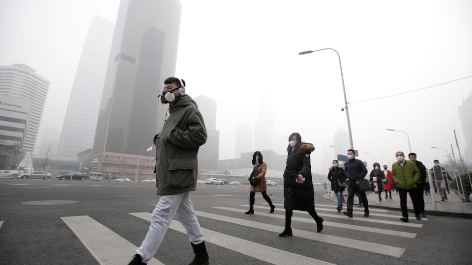 Des passants plongÃ©s dans le smog.