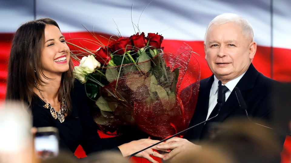 Jaroslaw Kaczynski reçoit des fleurs. Les sondages à la sortie des urnes le donnent, lui et son parti Droit et Justice (PiS), gagnant.