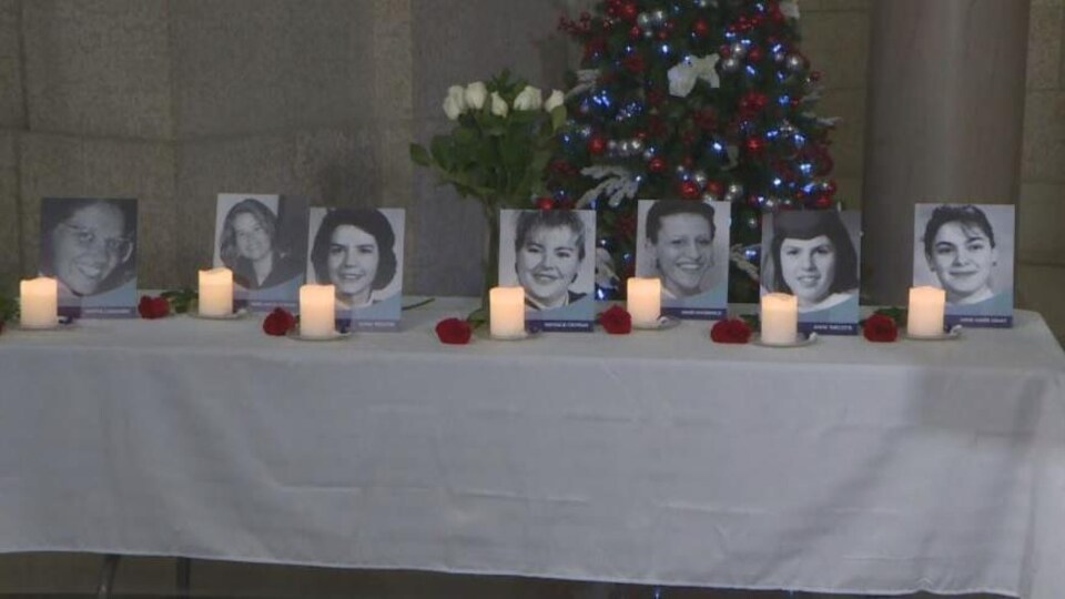 Des chandelles à côté des photos en noir et blanc des victimes tuées à l'École polytechnique de Montréal.