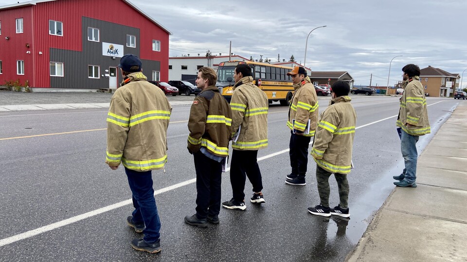 Des futurs pompiers traversent la rue.