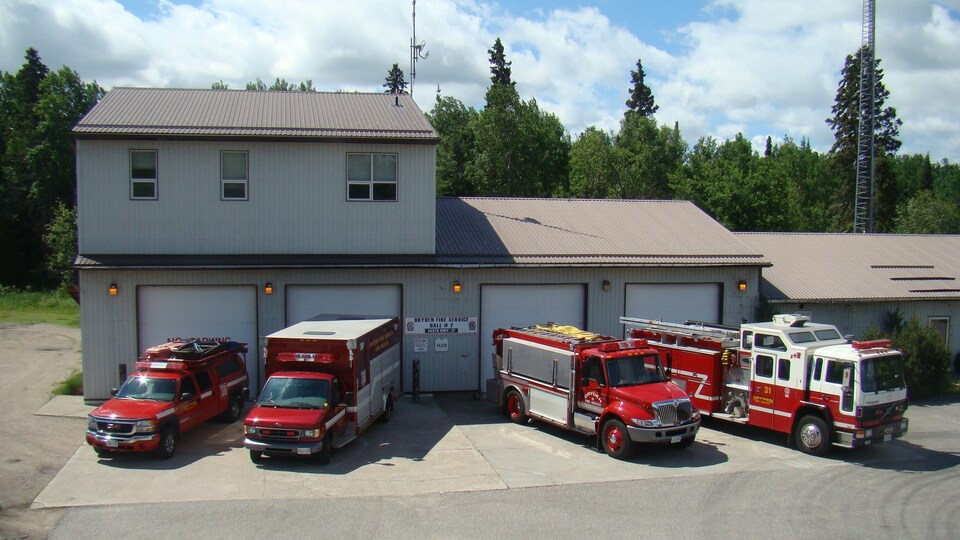 Quatre véhicules d'urgences sont garés devant le poste d'incendie/