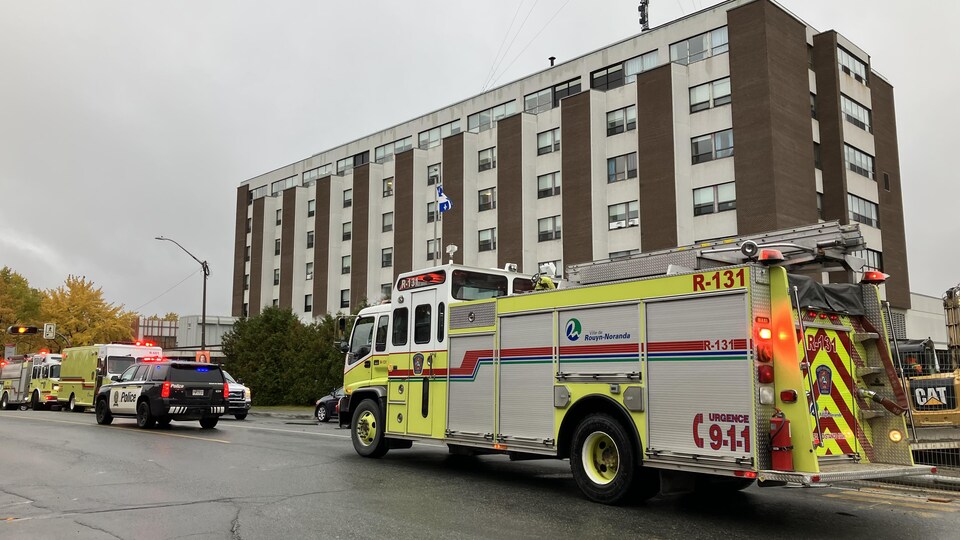Trois camions de pompiers et une voiture de la Sûreté du Québec sont stationnés devant l'Hôpital de Rouyn-Noranda.