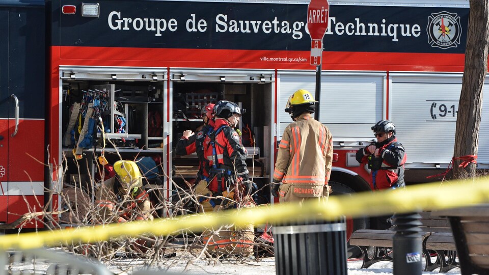 Des pompiers se préparant devant leur camion.