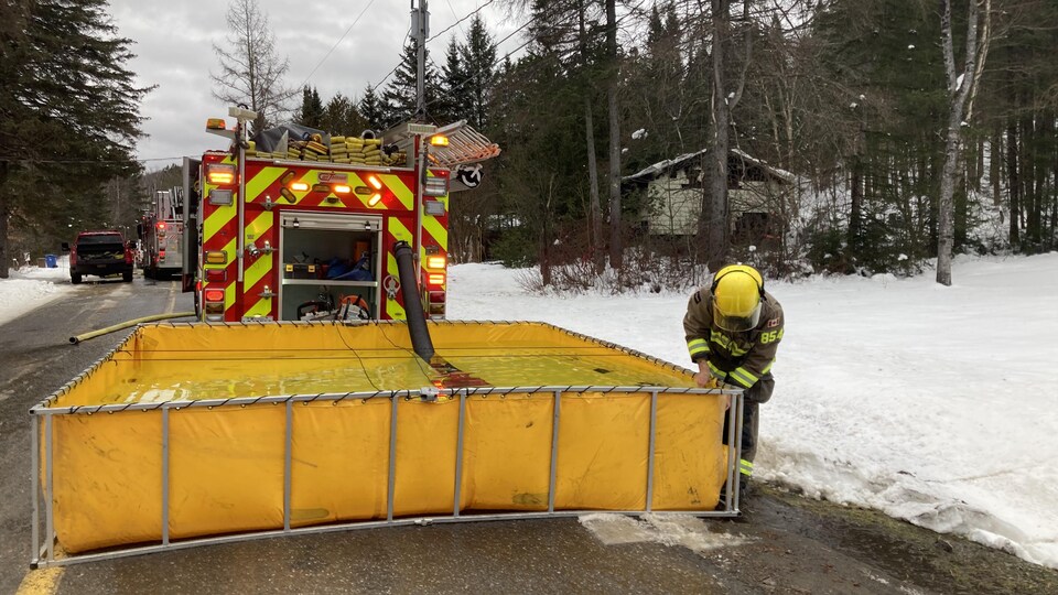 Un bassin carré jaune rempli d'eau derrière un camion.