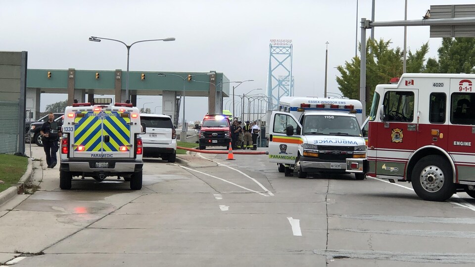 L'accès au pont est bloqué par plusieurs véhicules de police et des services d'urgence.