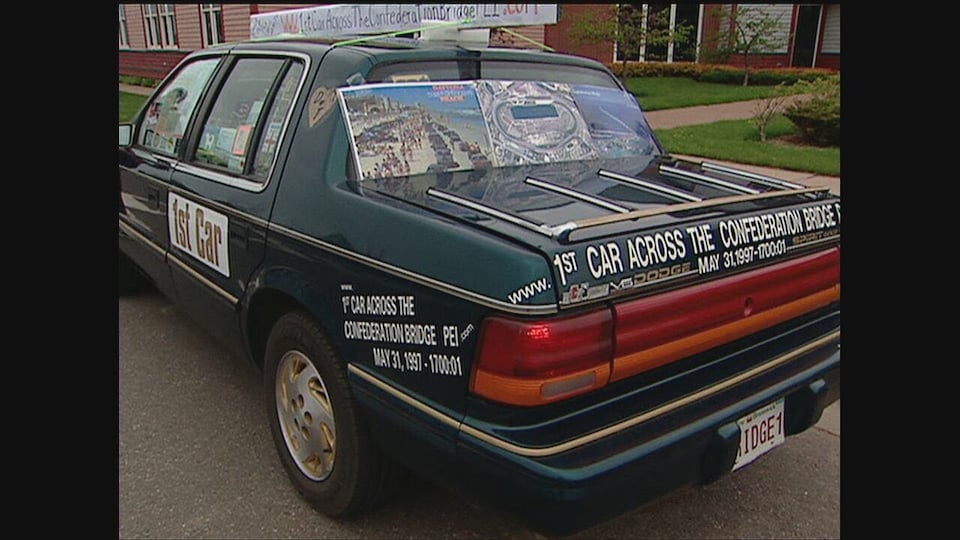 Une Dodge Spirit sur lequel est écrit « première voiture à avoir traversé le pont de la Confédération, le 31 mai 1997 »