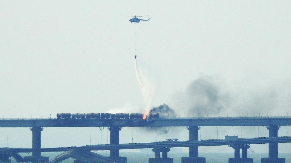 Un hélicoptère déverse de l'eau sur les wagons pour tenter d'éteindre le feu.