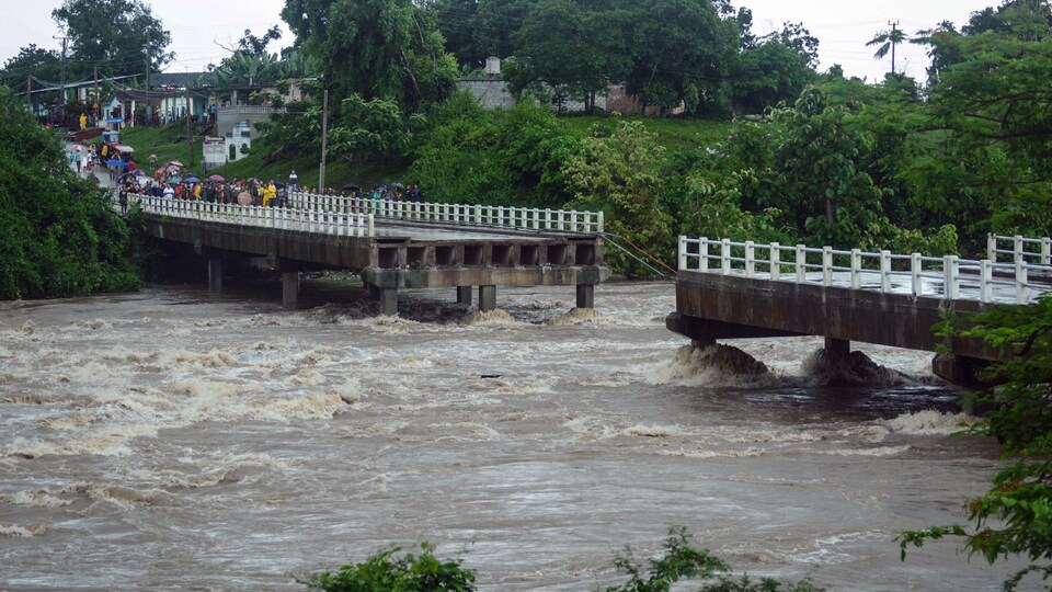 Un pont emporté par une rivière en crue.