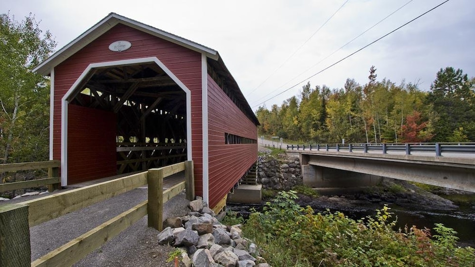 Ce pont couvert est construit en bois et peint en rouge.