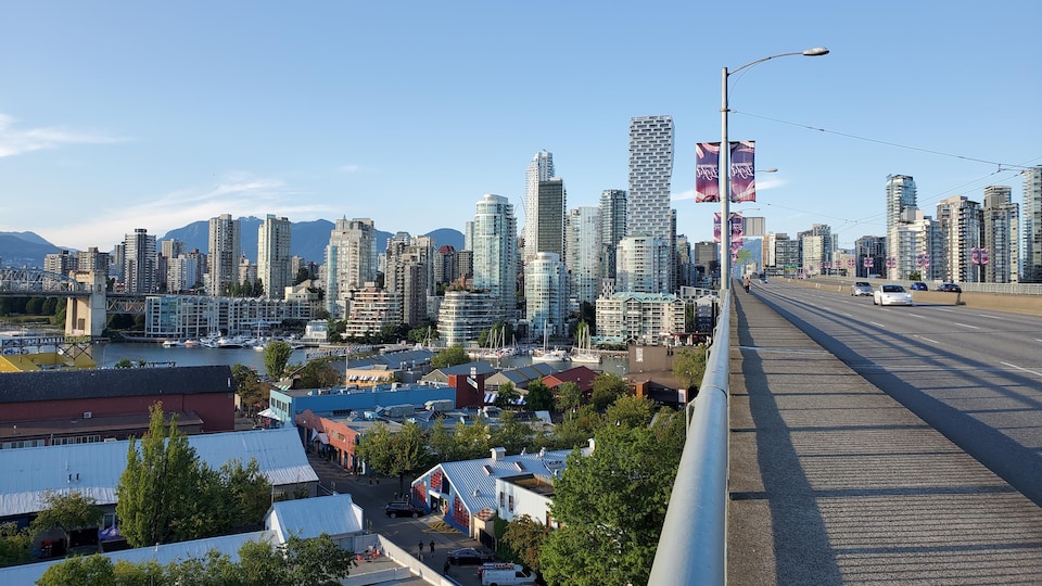 Vue en plongée sur une île et sur les gratte-ciel de Vancouver depuis un pont.