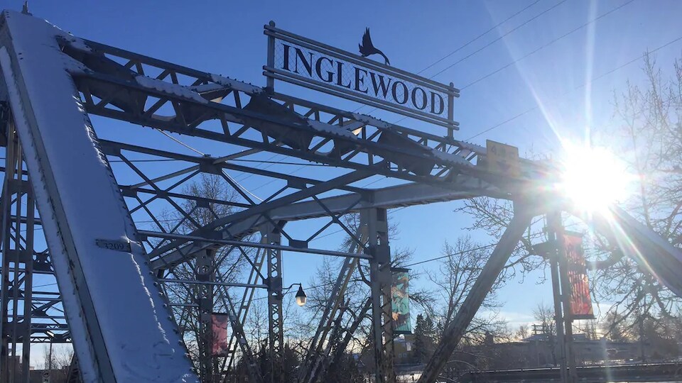 Une voiture noire passe sur un pont. Son nom, Inglewood, est inscrit sur le dessus de la structure.