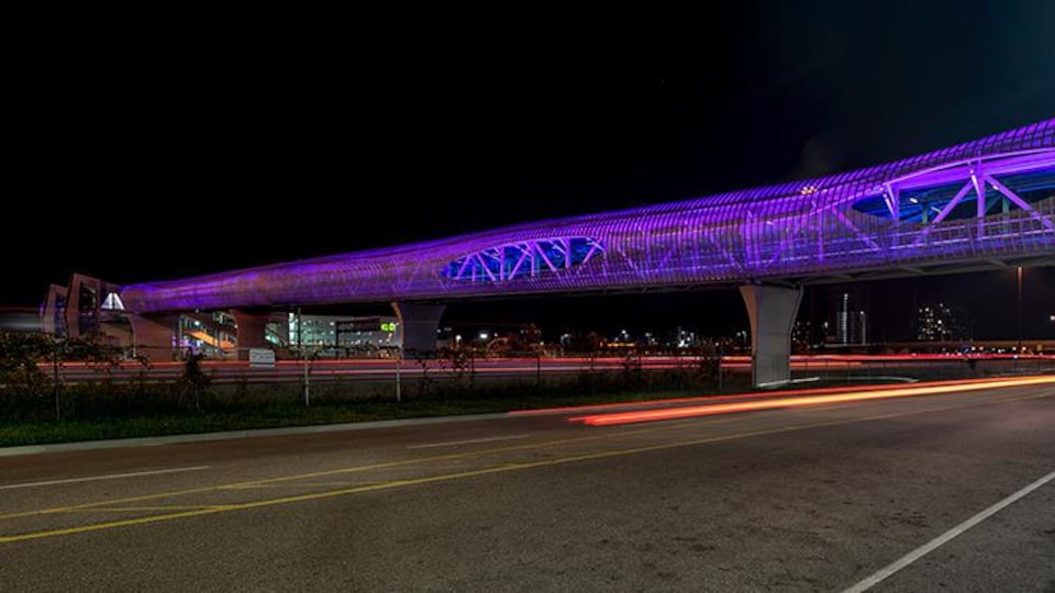 Un pont piétonnier couvert la nuit.