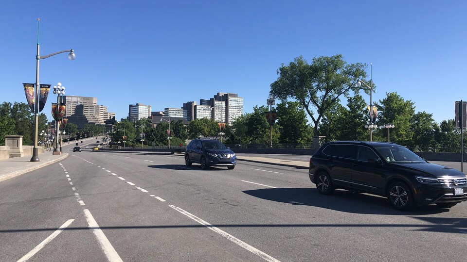 Deux voitures passent sur la rue près du pont interprovincial.