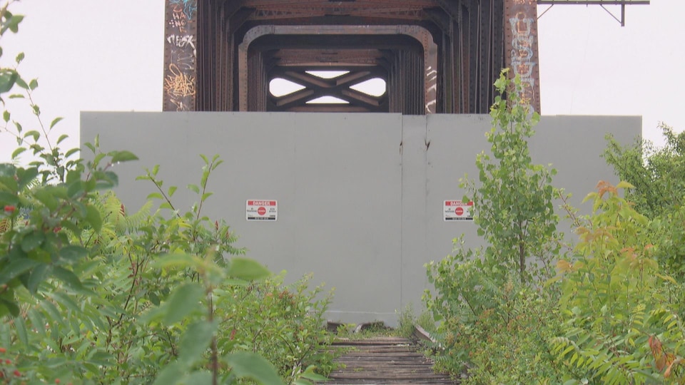 Une structure de métal est érigée et on peut voir un signe indiquant que l'endroit est interdit d'accès.