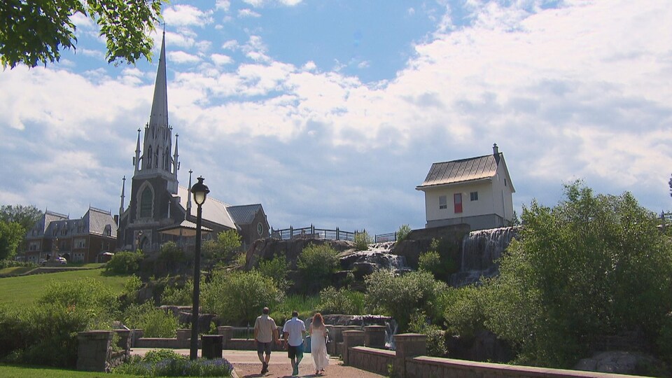 Trois personnes marchent près de la petite maison blanche