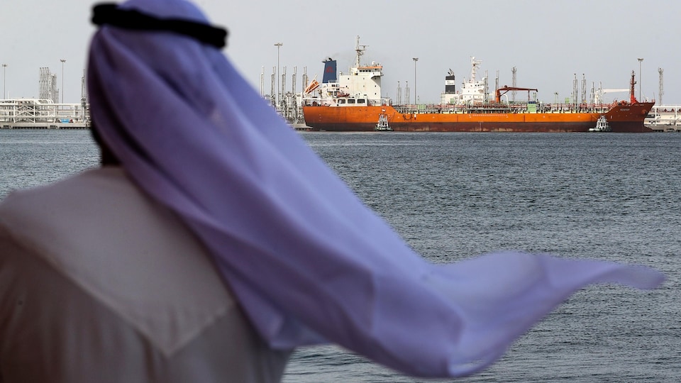 Un homme regarde un navire au port de Fujairah, aux Émirats arabes unis.