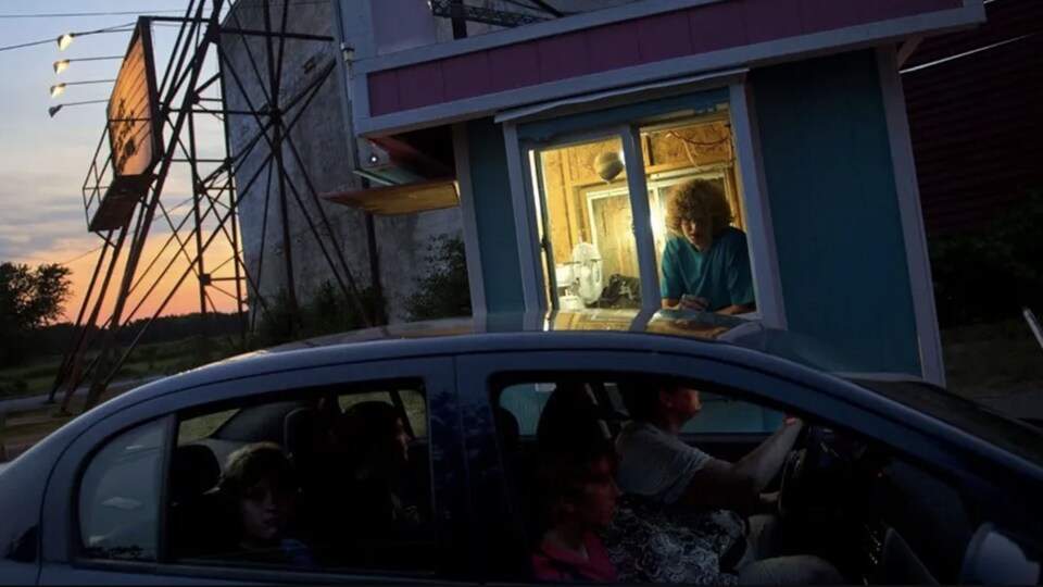 Une voiture commande un ticket au box office d'un ciné-parc.