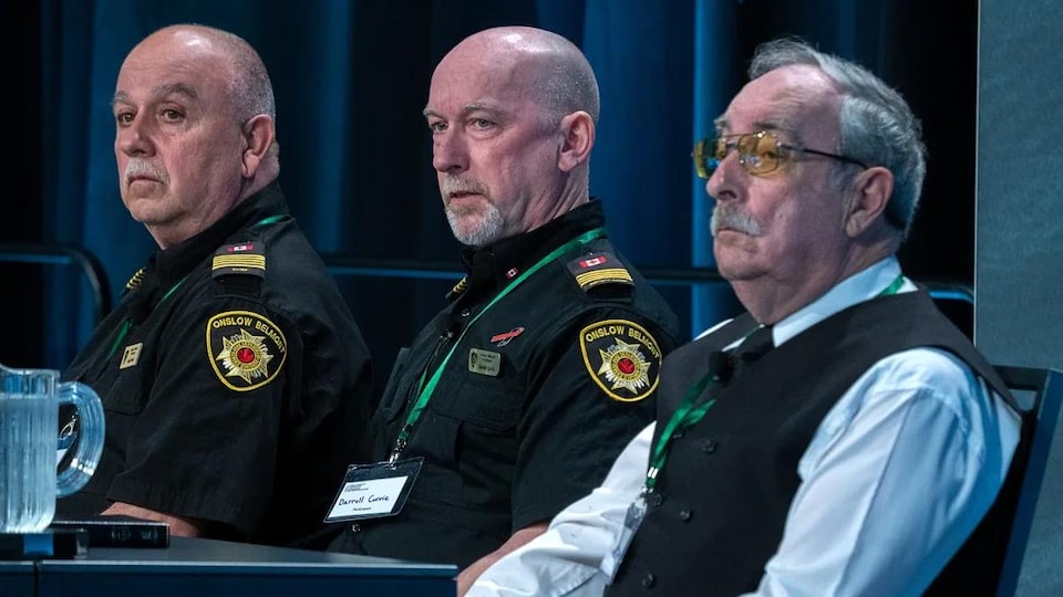 Trois hommes assis témoignent devant la Commission des pertes massives.