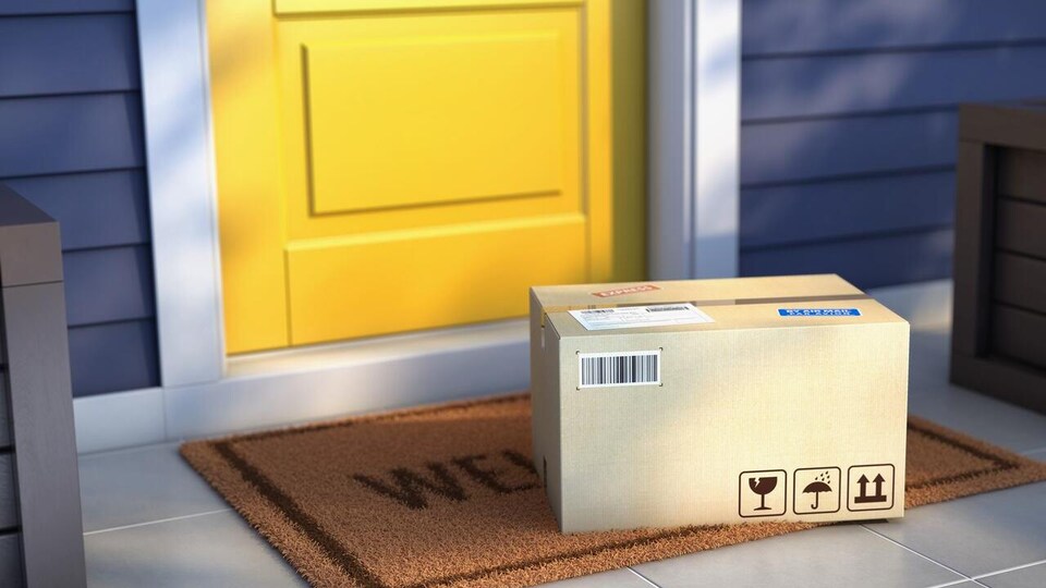 Une boîte de livraison déposée devant une porte jaune extérieure. 