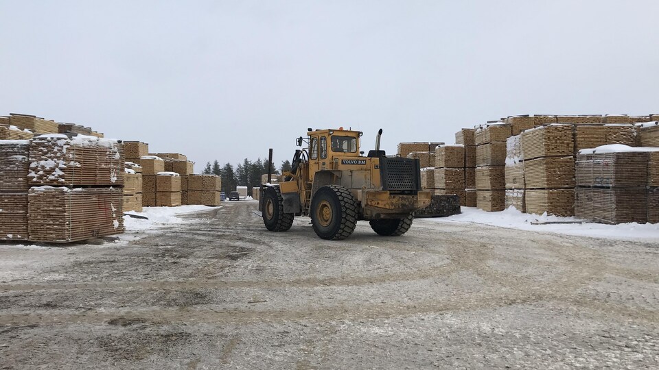 Un camion lourd dans une cour d'usine de bois d'oeuvre.