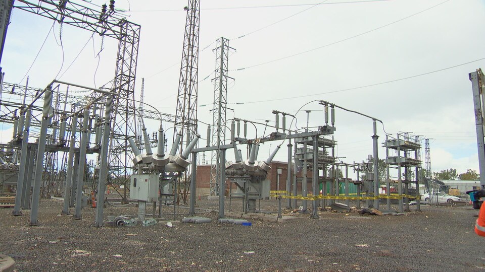 Des structures fortement endommagées d'un poste d'électricité. Des morceaux d'équipement brisés jonchent le sol.