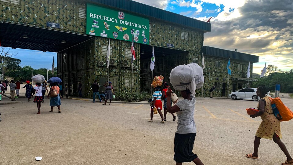 Des Haïtiens se dirigeant vers la frontière avec des sacs.