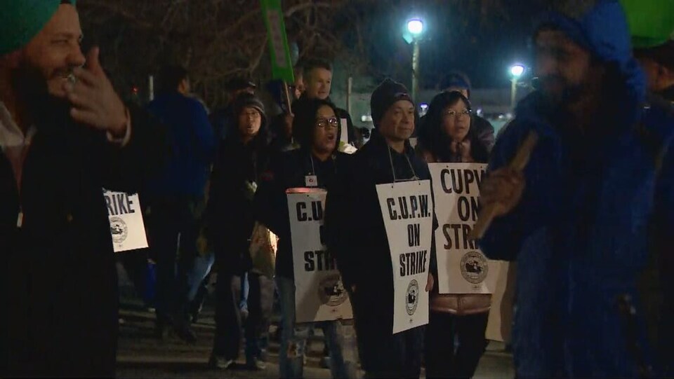 Des travailleurs de Postes Canada font du piquetage à Calgary.
