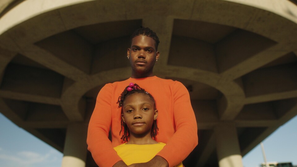 Un homme et une petite fille qui se tient devant lui.