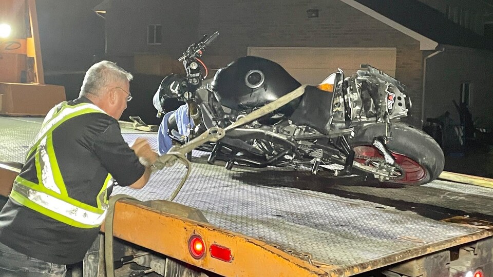 Une motocyclette endommagée est placée sur une dépanneuse.