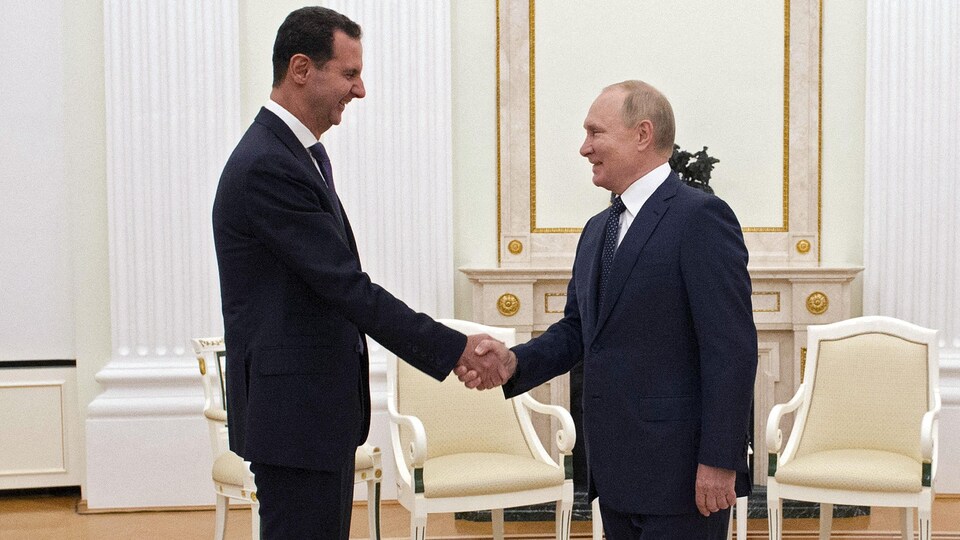 Vladimir Poutine et Bachar Al-Assad se serrant la main.