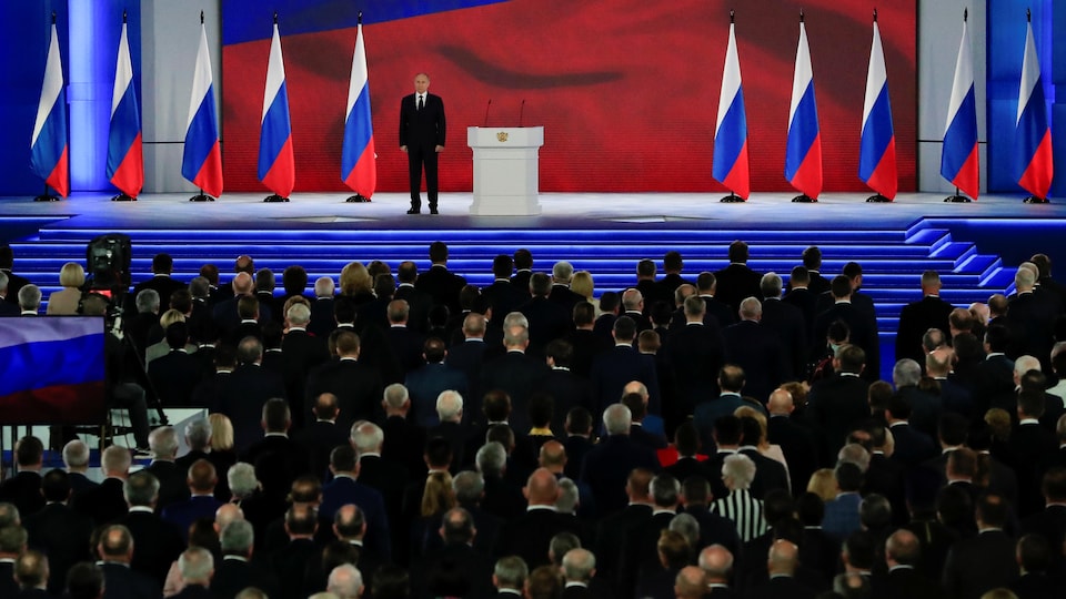 Vladimir Putin en el escenario ante una audiencia de parlamentarios. 