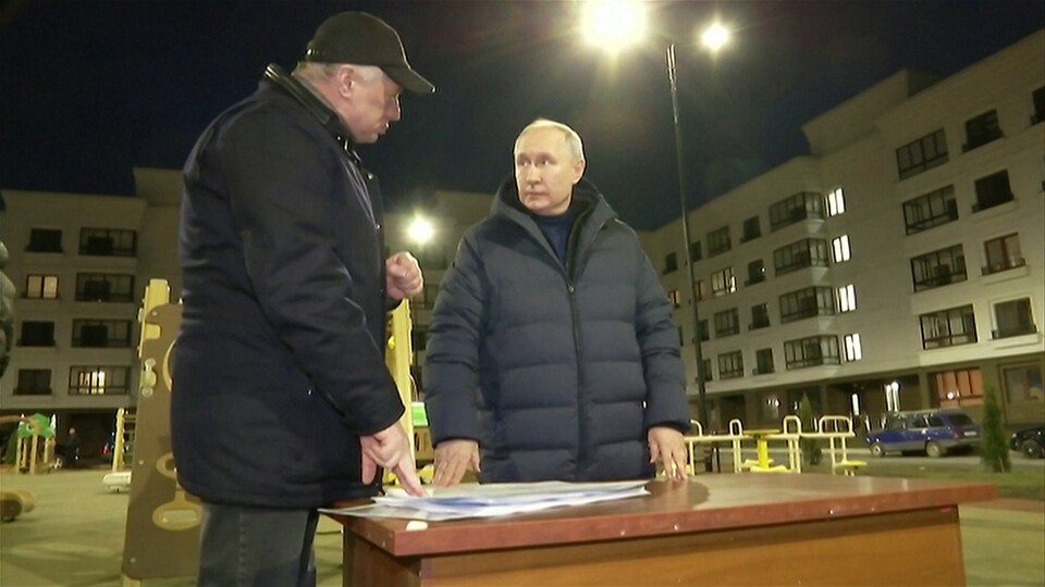 Vladimir Poutine discute avec quelqu'un lors de sa visite à Marioupol.