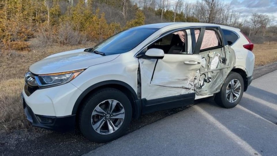 Une voiture dont un des côtés a de toute évidence été défoncé par un objet.
