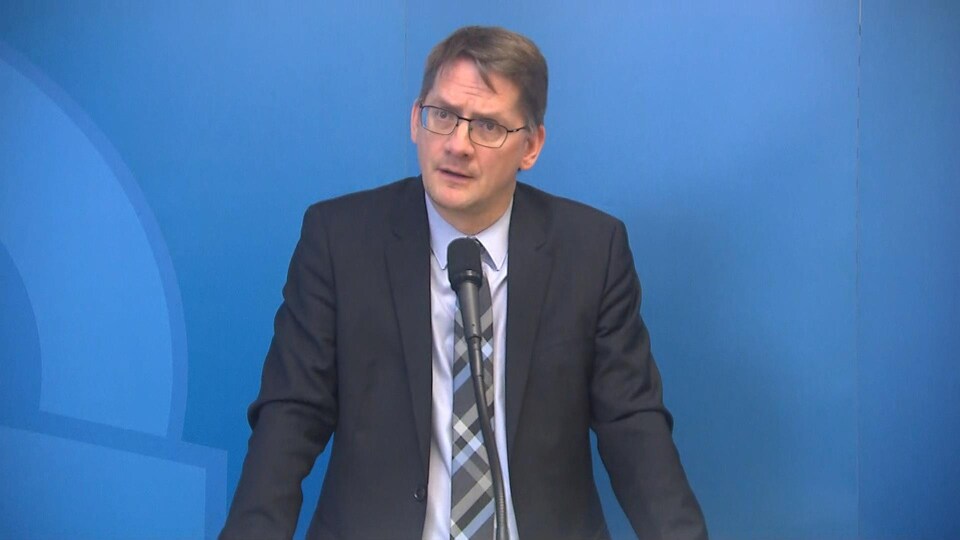 L'homme fait face à un micro lors d'une conférence de presse