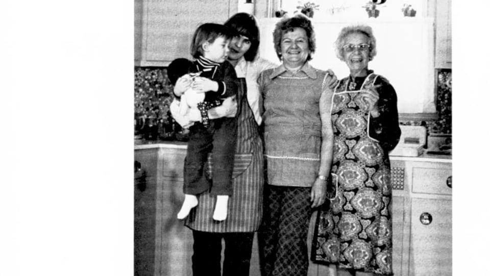 Trois femmes et un enfant posent pour la photo en noir et blanc