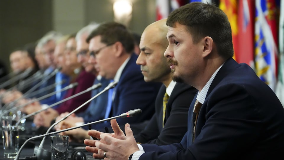 Le premier ministre du Nunavut, P.J. Akeeagok (à droite) est assis à une table avec les premiers ministres des autres provinces et territoires au pays, mardi le 7 février 2023, à Ottawa.