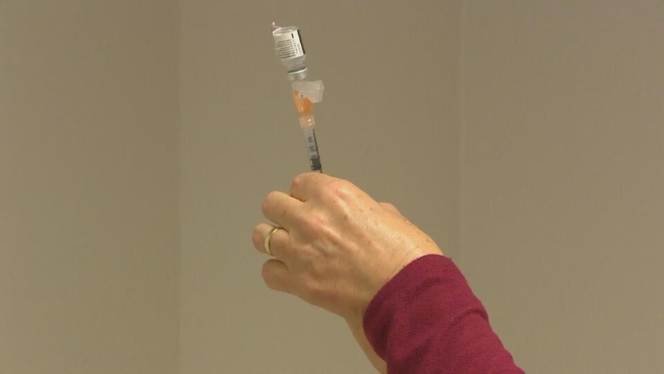 Une infirmière prépare une dose du vaccin contre la COVID-19.