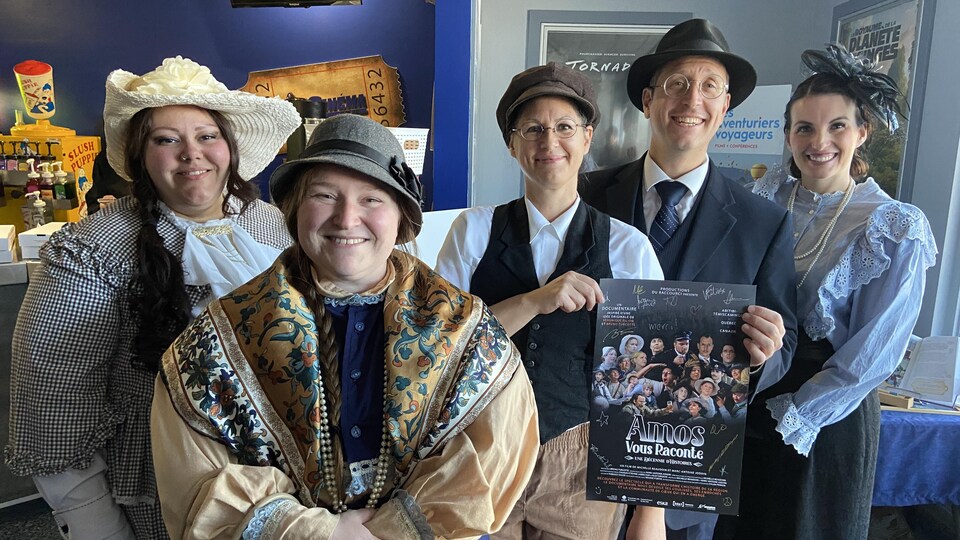 Les cinq comédiens en costume d'époque posent avec l'affiche du documentaire dans l'entrée du cinéma Amos.