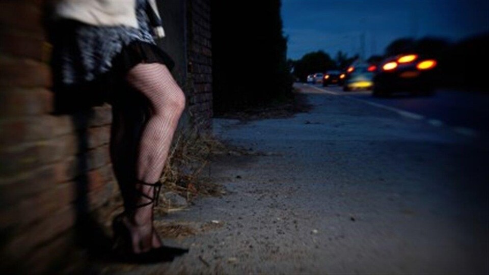 Une femme dans la rue, dont on voit juste les jambes.