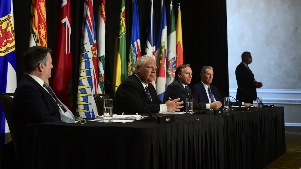 Les quatre premiers ministres sont assis à une table en conférence de presse.