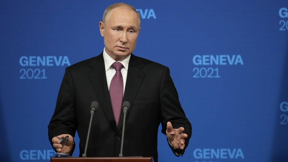 Vladimir Poutine est debout et parle dans deux micros.