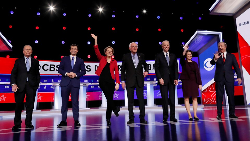 Des politiciens saluent la foule sur une scène.